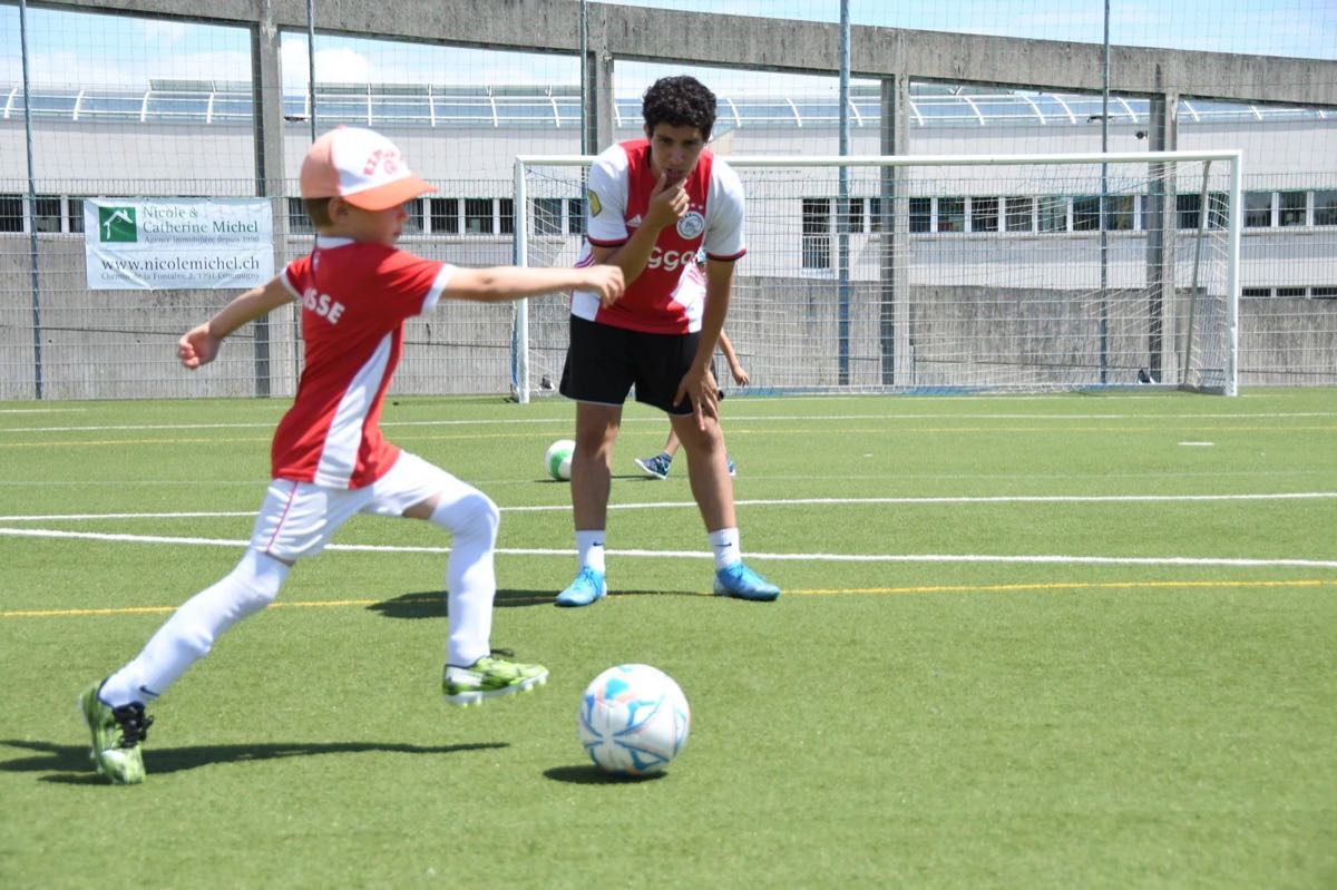Un enfant frappe le ballon devant un coach, aux débuts de Happy Feet en 2020